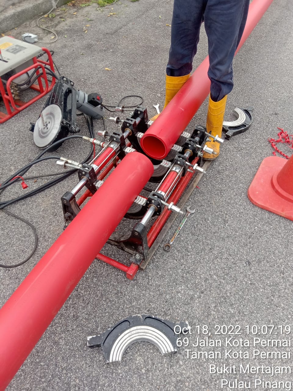 Butt-fusion pipe joining equipment with red HDPE ducts at Jalan Kota Permai, Bukit Mertajam, Pulau Pinang (October 2022).